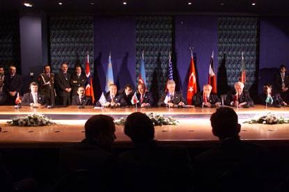 Leaders seated at a long table before a row of national flags at a signing ceremony in Istanbul in November 1999.