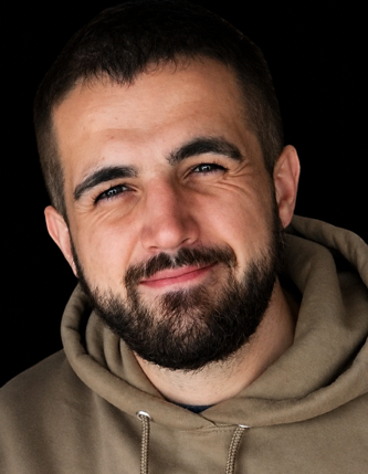 Portrait of Staff Sgt. Nigel W. Pajakowski, smiling in a hoodie